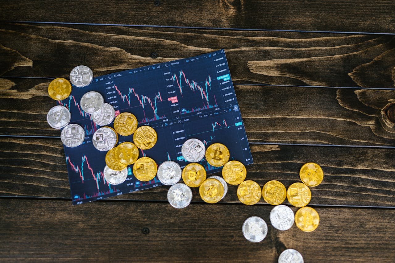 services-02 Gold and silver cryptocurrency coins scattered on a trading chart over a wooden table.
